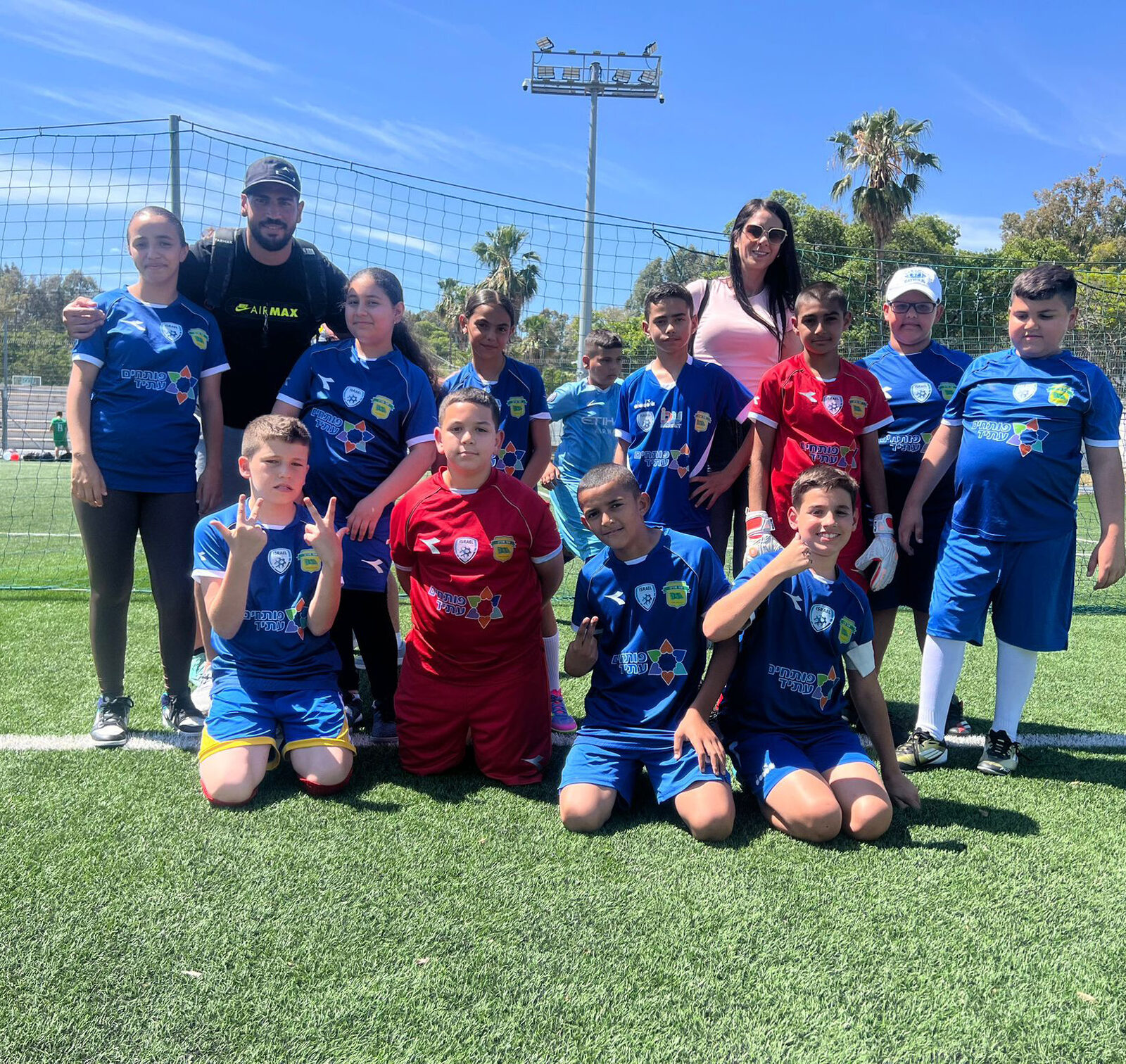 Equipo del Youth Futures Football Club posando en la cancha con su entrenador