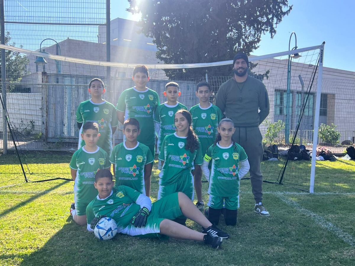Equipo con camiseta verde sentado en el césped con las pelotas